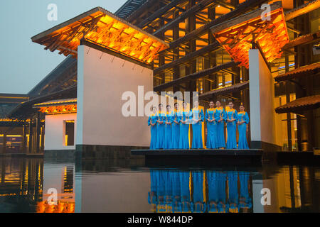 Freiwillige tragen (qipao Cheongsam) mit Phoenix Dekoration posieren vor dem wuzhen Internet International Convention Center vor der bevorstehenden Stockfoto