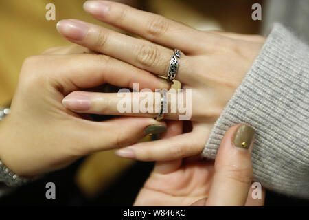 Chinesische e-commerce Schmuck Käufer Miffy hilft Ihren Kunden heraus zu versuchen, Schmuck von ihr in Shanghai, China, 9. November 2016 vorgesehen. Miffy, ein Schmuck p Stockfoto