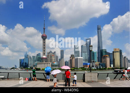 ---- Touristen besuchen die Promenade am Bund entlang des Flusses Huangpu das Stadtbild der Lujiazui Financial District mit der orientalischen Pe anzeigen Stockfoto