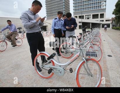 Lokale chinesische Bewohner verwenden Sie die App von mobike auf ihren Smartphones neue - und leichtere Version Fahrräder von Mobike in Shanghai, China, 19. Oktober zu vermieten Stockfoto