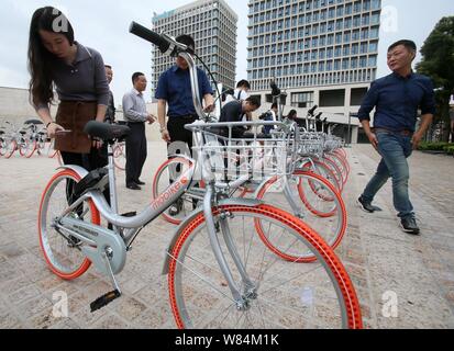 Lokale chinesische Bewohner verwenden Sie die App von mobike auf ihren Smartphones neue - und leichtere Version Fahrräder von Mobike in Shanghai, China, 19. Oktober zu vermieten Stockfoto