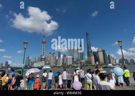 ---- Touristen besuchen die Promenade am Bund entlang des Flusses Huangpu das Stadtbild der Lujiazui Financial District mit der orientalischen Pe anzeigen Stockfoto