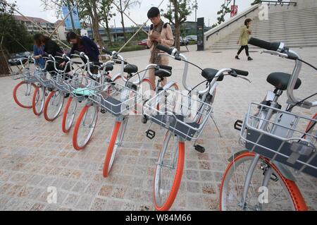 Lokale chinesische Bewohner verwenden Sie die App von mobike auf ihren Smartphones neue - und leichtere Version Fahrräder von Mobike in Shanghai, China, 19. Oktober zu vermieten Stockfoto