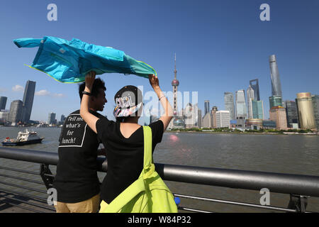 ---- Touristen besuchen die Promenade am Bund entlang des Flusses Huangpu das Stadtbild der Lujiazui Financial District mit der orientalischen Pe anzeigen Stockfoto