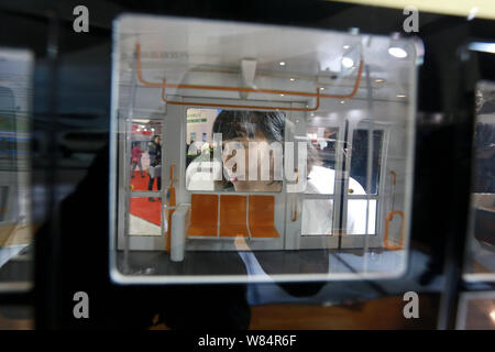 ---- Ein Besucher schaut in ein Modell U-Bahn auf dem Display während Metro China 2015 in Peking, China, 17. November 2015. Chinas Investitionen in der U-Bahn Stockfoto