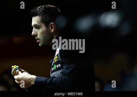 Mark Selby von England Kreiden seine Cue als hält er einen Schuß gegen Ryan Day von Wales während ihrer Viertelfinale der 2016 World Snooker Shanghai Mas Stockfoto