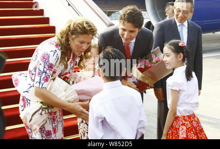 Kanadische Premierminister Justin Trudeau, Mitte, und seine Frau Sophie Gregoire, links, halten Blumensträuße nach Gepäckablagefächer über den Sitzen, mit ihrer Tochter Ella - Stockfoto