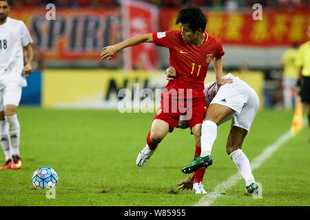 Hao Junmin von China, Links, Herausforderungen, die ein Spieler von Iran während einer Gruppe ein Fußballspiel der FIFA WM 2018 asiatischen Qualifier Final in Shenyang cit Stockfoto