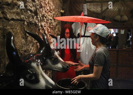 Ein Tourist reagiert als weibliche Mitarbeiter in Zombie Kostüm bietet ihr Gewebe angezogen, nachdem sie ihre Hände in ein Zombie gewaschen - themed Wc in Hangzhou Pa Stockfoto