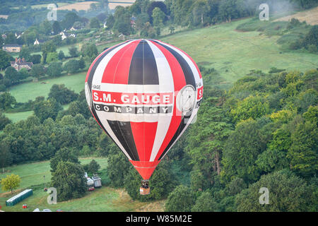 Ein Ballon schwimmt über Ashton Hof Immobilien in der ersten Donnerstag Masse Aufstieg an der Bristol International Balloon Fiesta, wo hunderte von Ballons hoffen, über das Wochenende vor der vorhergesagten Stürme über England zu fliegen. Stockfoto