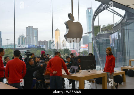 ------ Chinesische Mitarbeiter tragen rote T-Shirts Kunden an einem neu - Apple Store in der Stadt Guangzhou eröffnet, südöstlich von China Guangdong provinc Stockfoto