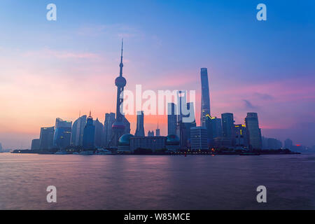 ---- Stadtbild bei Sonnenuntergang der Lujiazui Financial District mit den Oriental Pearl TV Tower, dem höchsten Links, dem Shanghai Tower, dem höchsten rechts und Stockfoto