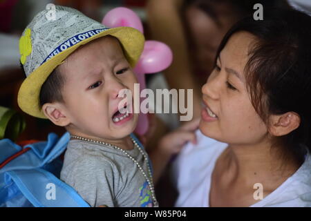 Eine chinesische Mutter Komfort ihr Sohn in einem Kindergarten weinend am ersten Tag des neuen Semesters in Qionghai City, South China Hainan Provinz, 1 Sep Stockfoto