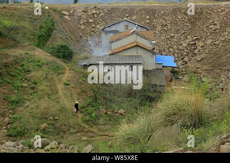 Ein Nagel Haus, dessen Besitzer weigerte sich wegen Streitigkeiten über Entschädigung details zu verschieben ist in einer Grube auf der Baustelle eines industriellen isoliert Stockfoto