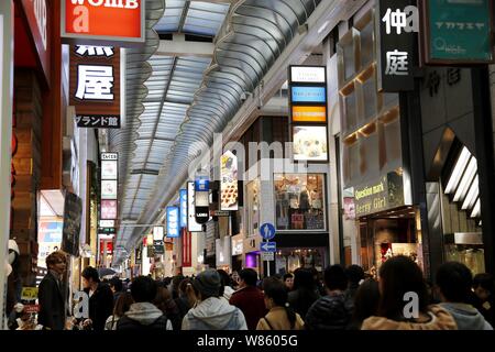 ------ Chinesische Touristen und Anwohner vorbei an Geschäften und Läden an der Shinsaibashi Shopping District in Osaka, Japan, 1. März 2015. Mit Th Stockfoto