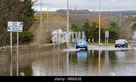 Überschwemmung - Überflutete Straße ist Unpassierbar zu Autos wie tiefe Wasser macht das Fahren gefährlich für Fahrzeuge - Burley in Bösingen, Yorkshire, England, UK. Stockfoto