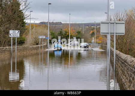 Überschwemmung - Überflutete Straße ist Unpassierbar zu Autos wie tiefe Wasser macht das Fahren gefährlich für Fahrzeuge - Burley in Bösingen, Yorkshire, England, UK. Stockfoto