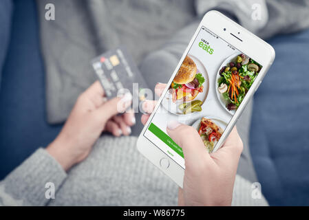 Kiew, Ukraine - Januar 24, 2018: Frau mit uber isst App auf Apple iPhone 8 Plus zu Hause für Essen, Lieferung Stockfoto