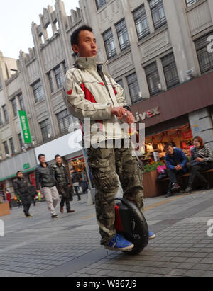 --FILE - Ein chinesischer Mann reitet auf einem elektrischen selbstausgleichenden Scooter auf einer Straße in Wenzhou, Zhejiang Provinz, China vom 24. Oktober 2012. Hoverb Stockfoto
