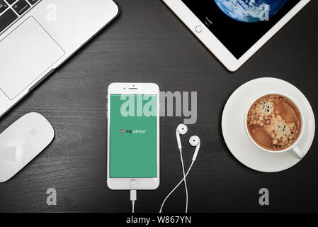 Kiew, Ukraine - Februar 6, 2018: Apple iPhone 8 plus mit Tripadvisor App auf dem Bildschirm mit dem Macbook, ipad, Kaffee und Kopfhörer in Schwarz, oben Stockfoto