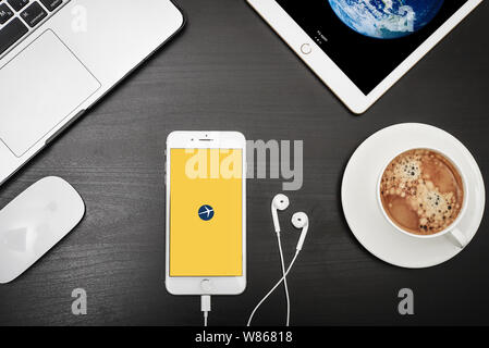 Kiew, Ukraine - Februar 6, 2018: Apple iPhone 8 plus mit Expedia App auf dem Bildschirm mit dem Macbook, ipad, Kaffee und Kopfhörer auf schwarzen Schreibtisch, Ansicht von oben Stockfoto