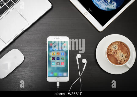 Kiew, Ukraine - Februar 6, 2018: Apple iPhone 8 plus mit Travel Apps auf dem Bildschirm mit dem Macbook, ipad, Kaffee und Kopfhörer auf schwarzen Schreibtisch, Ansicht von oben Stockfoto