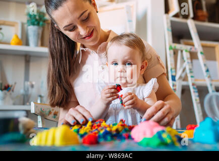 Mutter und Tochter spielen mit dem kinetischen Sand. Stockfoto