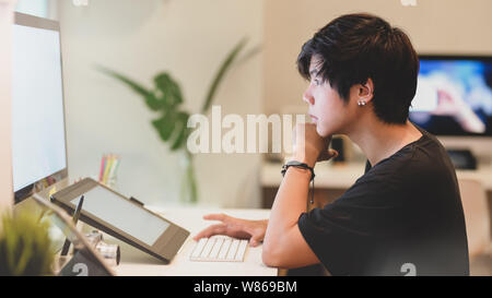 Junge professionelle Fotografen Bearbeitung sein Foto in komfortablen Büro Stockfoto