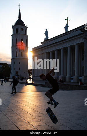 Vilnius, Litauen. Abend am Platz der Kathedrale mit Glockenturm auf dem Hintergrund und den Sonnenuntergang, jungen Skating Stockfoto