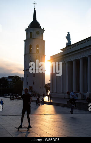 Vilnius, Litauen. Abend am Platz der Kathedrale mit Glockenturm auf dem Hintergrund und den Sonnenuntergang, jungen Skating Stockfoto