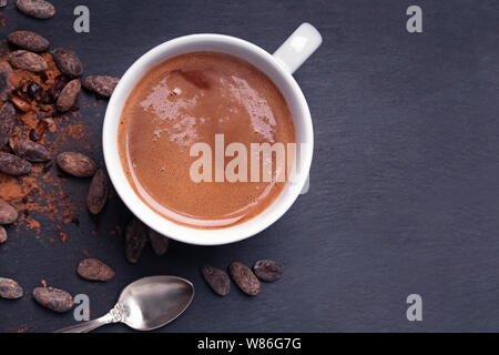 Heiße Schokolade oder Kakao in einem Becher auf dem schwarzen Hintergrund, Ansicht von oben Stockfoto