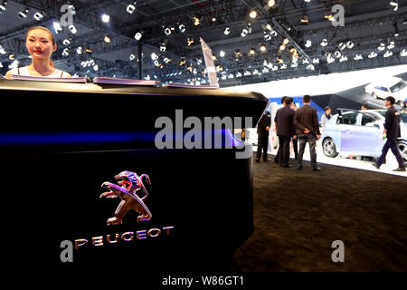 ---- Ein chinesischer Mitarbeiter ist auf dem Stand von Peugeot in der 16. Shanghai Internationalen Automobil Ausstellung zu sehen, die auch als Auto S bekannt Stockfoto