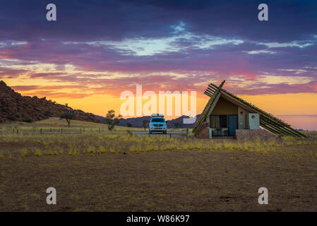 Sonnenaufgang über kleine Chalets eines Desert Lodge in der Nähe von Sossusvlei in Namibia Stockfoto