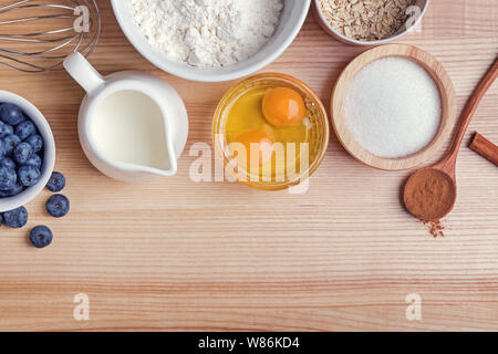 Zutaten für blueberry muffins Vorbereitung auf Holztisch, Ansicht von oben. Backvorgang. Stockfoto