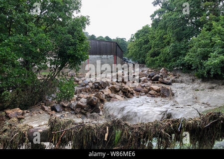 Felsbrocken und andere Rückstände nach einer flutartigen Überschwemmung durch sintflutartige Regenfälle fegte durch Holme Farm, Arkengarthdale, North Yorkshire, UK verursacht Stockfoto