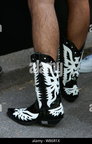 Mailand, Italien - 17 Juni, 2019: der Mann, der mit schwarzen und weißen Leder Stiefel cowboy hingewiesen, bevor Fendi fashion show, Mailand Fashion Week street style Stockfoto