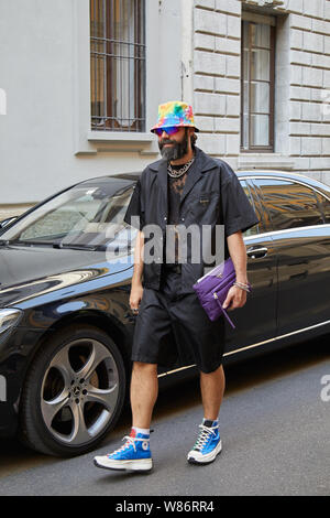 Mailand, Italien - 17 Juni, 2019: der Mann, der mit schwarzen Prada Hemd und lila Tasche, bevor Giorgio Armani Fashion Show, Mailand Fashion Week street style Stockfoto