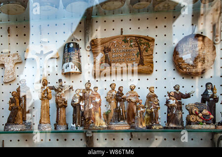 Statuetten in einem Souvenirladen in Assisi. Perugia, Umbrien, Italien Stockfoto