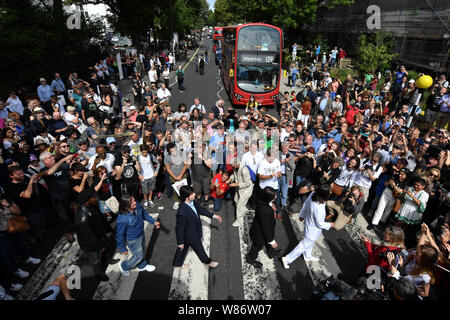 Beatles-Doppelgänger Band 'Fab Four' verbindet Beatles Fans, da Sie in der Abbey Road Kreuzung in London am 50. Jahrestag der Band tun es für ihre legendären Album Cover am 8. August 1969. Stockfoto