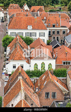 Elburg, Niederlande, 3. August 2019: verschiedene Häuser in der Altstadt mit Ziegel- oder weiß verputzten Wänden und roten Dachziegeln vom Turm der Th gesehen Stockfoto