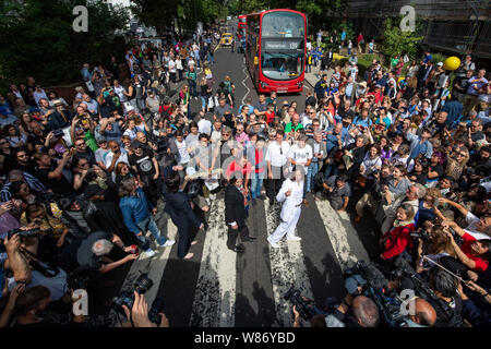 Beatles-Doppelgänger Band 'Fab Four' verbindet Beatles Fans, da Sie in der Abbey Road Kreuzung in London am 50. Jahrestag der Band tun es für ihre legendären Album Cover am 8. August 1969. Stockfoto