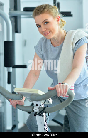 Porträt der sportliche junge Frau hört Musik beim Training im Fitnessraum Stockfoto