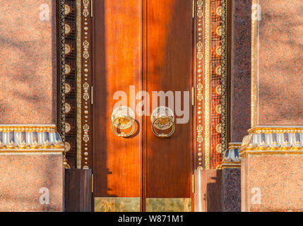 Alte hölzerne Tor mit zwei goldenen Türklopfer in der Nähe Ringe vorne sehen. Alte Tür Fragment des buddhistischen Tempel Datsan Gunzechoyney. Stockfoto