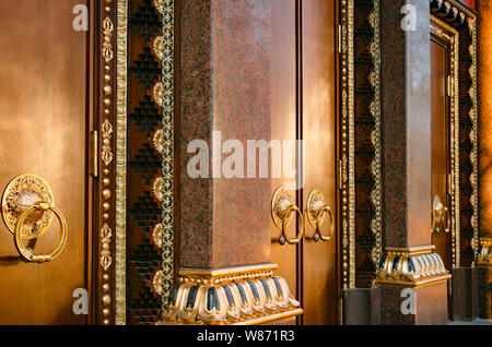Alte hölzerne Tor mit zwei türklopfer Ringe close-up von der Seite. Alte Tür Fragment des buddhistischen Tempel Datsan Gunzechoyney. Stockfoto