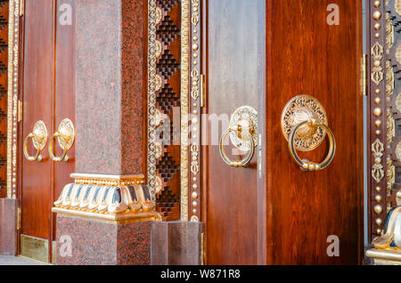 Alte hölzerne Tor mit zwei türklopfer Ringe close-up von der Seite. Alte Tür Fragment des buddhistischen Tempel Datsan Gunzechoyney. Stockfoto