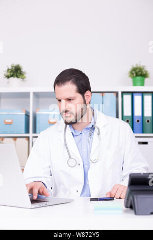 Bärtige Doktor in seinem Büro arbeiten. Geschäft und medizinischen Konzept. Stockfoto