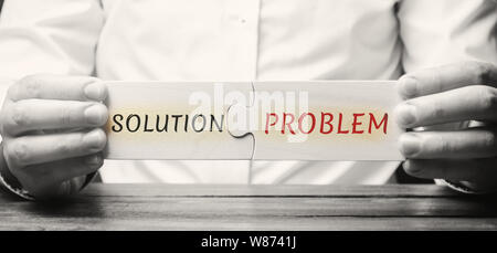 Geschäftsmann sammelt Puzzles aus Holz mit dem Wort Lösung Problem. Eine Strategie zur Überwindung der Probleme und Schwierigkeiten. Konzept die Motivation. Stockfoto