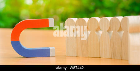 Hölzerne Figuren von Menschen und einem Magneten. Team Management Konzept. Human Resources. Fördern. Die Wahl eines neuen Vorsitzenden und der Einstellung von Mitarbeitern zu arbeiten. Abwerben Stockfoto