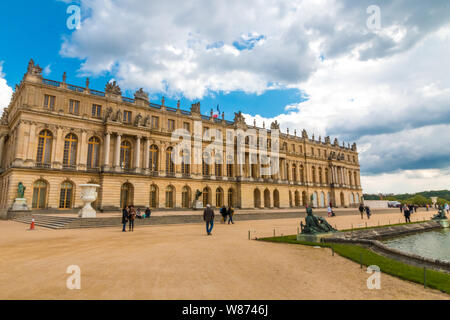 Schöne Sicht auf die Westfassade des berühmten Schlosses von Versailles aus dem Wasser Parterre an einem sonnigen Tag mit blauen Himmel. Die beliebte touristische Website... Stockfoto