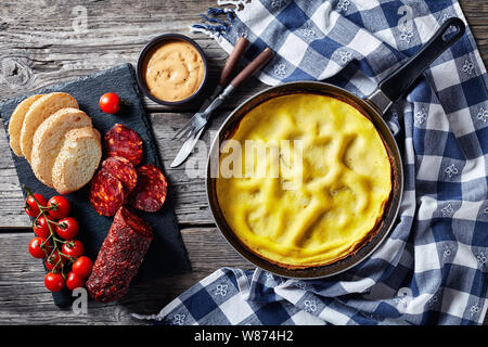 Hot Omelette in einer Pfanne, in Scheiben Chorizo, Brot und Tomaten auf einer Schiefertafel, Ansicht von oben, flach, kopieren Raum Stockfoto